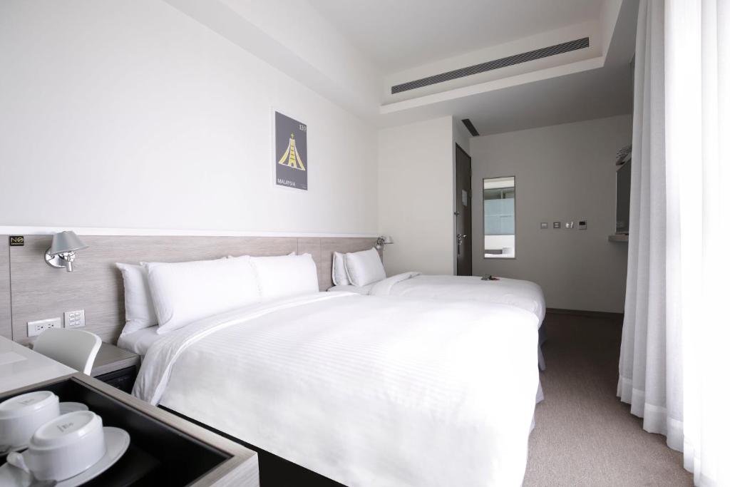 a white bedroom with a large white bed in it at CityInn Hotel Plus- Fuxing North Road Branch in Taipei