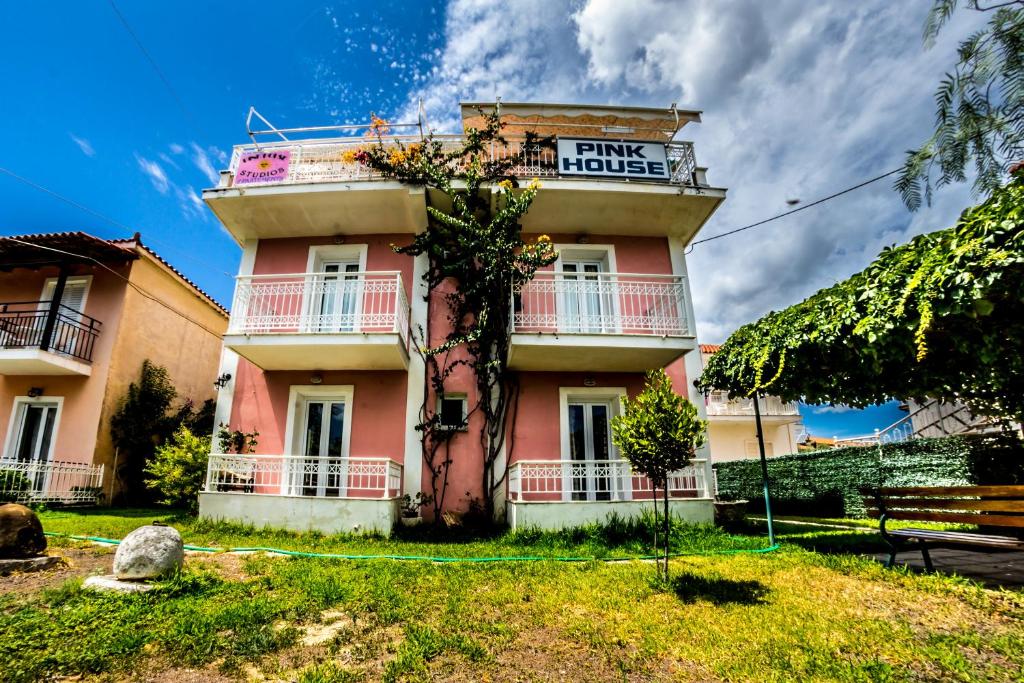 un edificio rosa con un cartello che legge la casa rosa di Terra Azzura a Laganas