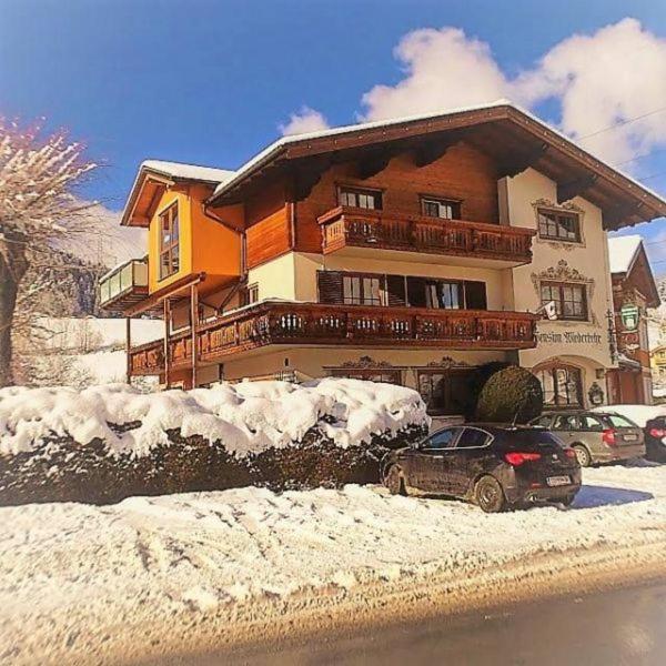 ein Haus im Schnee mit Autos vor dem Haus in der Unterkunft Privatzimmervermietung Wiederkehr in Altenmarkt im Pongau