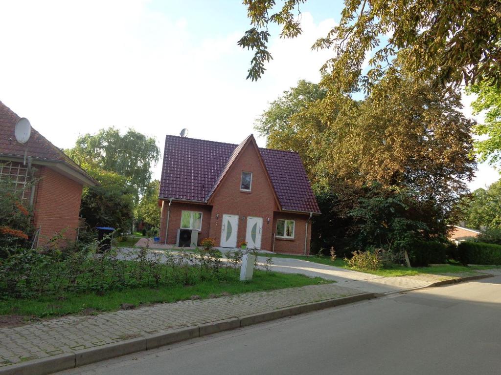 a red house with a red roof on a street at Haus-Hempel-1 in Groß Mohrdorf