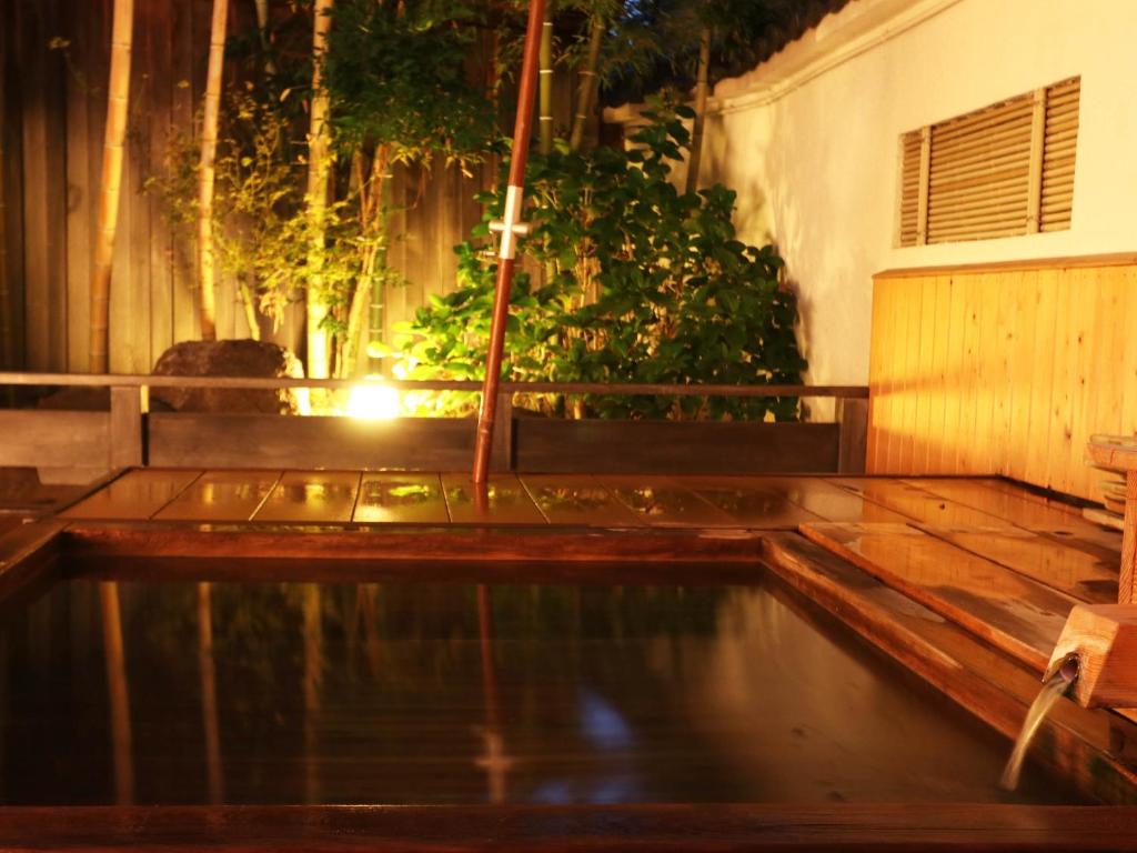 a pool of water on a wooden deck at night at Yanagiya in Kofu