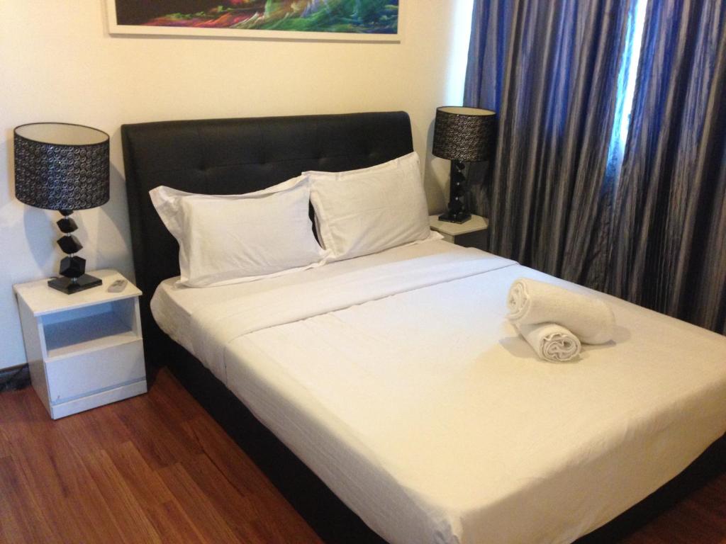 a bedroom with a bed with a hat on it at Elegant Suites at Taragon Bukit Bintang in Kuala Lumpur