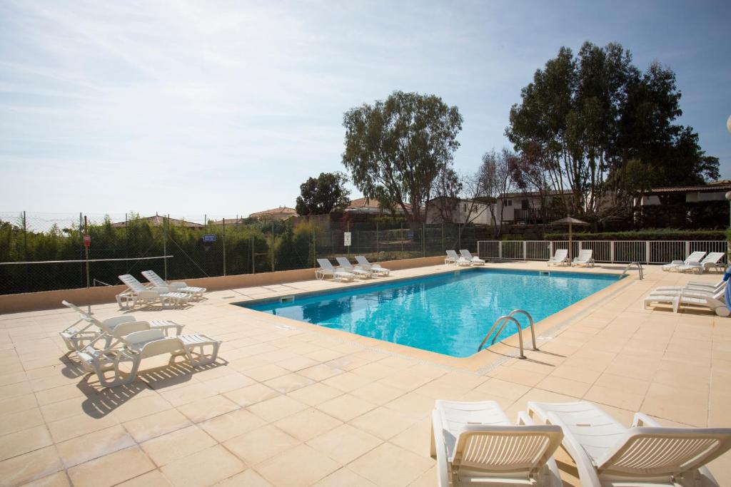 a pool with chaise lounge chairs and a bunch at Village Vacances Le Kangourou (by Popinns) in Fréjus