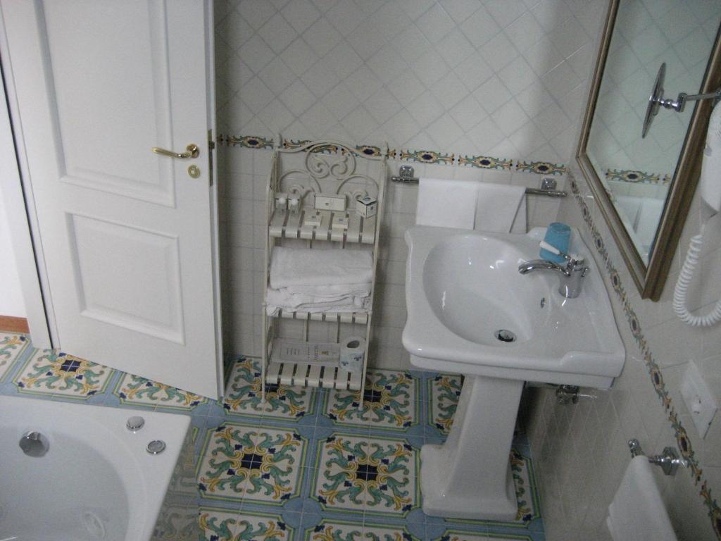 a small bathroom with a sink and a toilet at Hotel Belvedere in Conca dei Marini