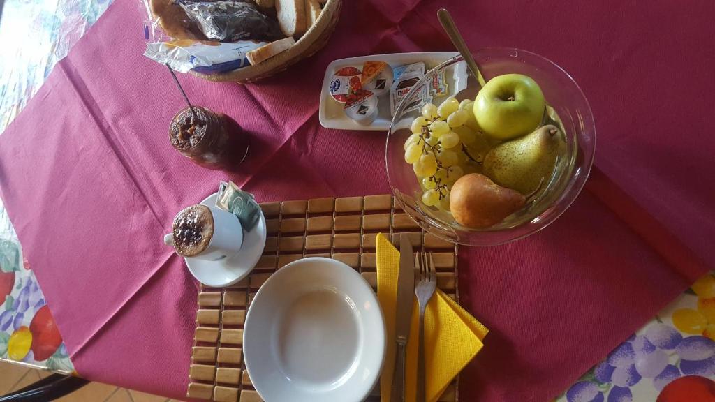 a table with a bowl of fruit on a pink table cloth at Ecochiocciola in Montese