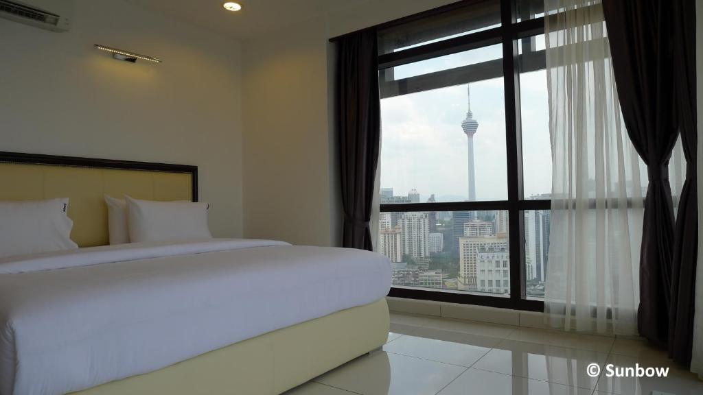 um quarto com uma cama e uma grande janela em Sunbow Suites @ Times Square Kuala Lumpur em Kuala Lumpur