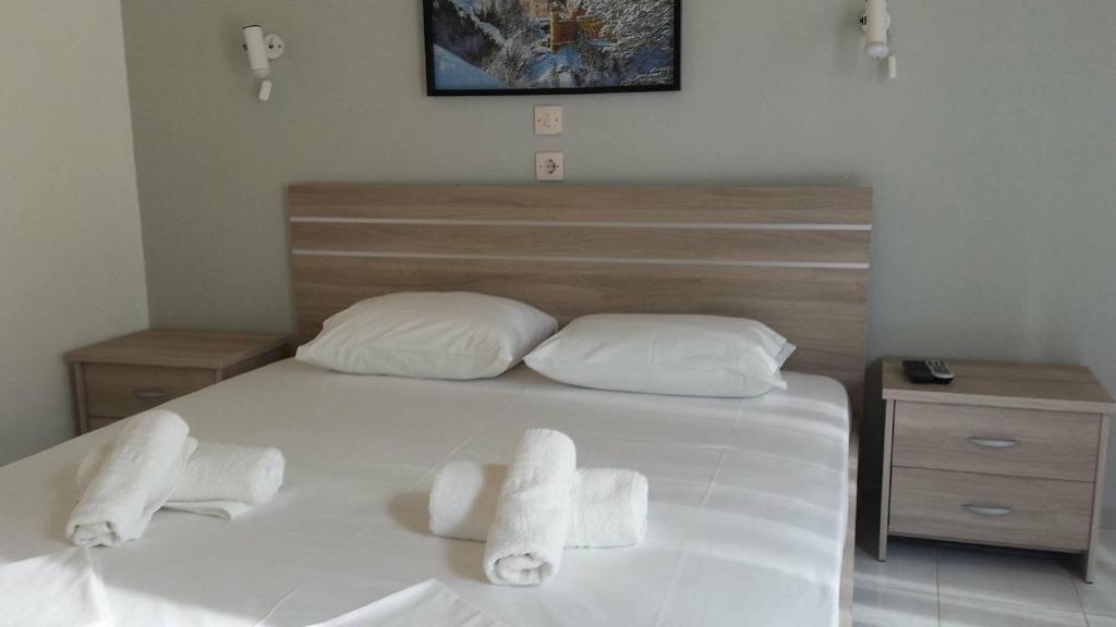 - une chambre avec un lit blanc et des serviettes dans l'établissement Studios Ntina, à Alikí