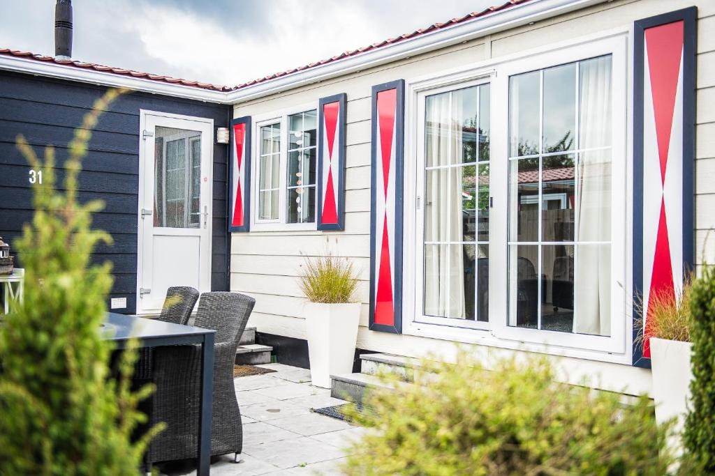 a house with red white and blue trim at Chalet 31 in Serooskerke