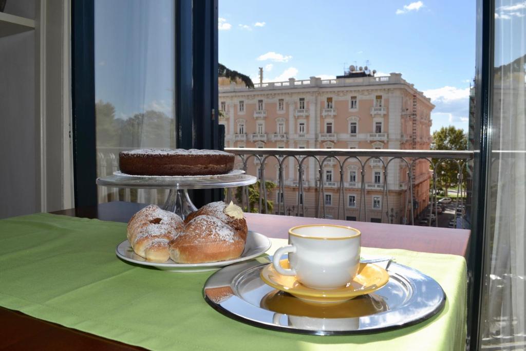 - une table avec deux assiettes de pâtisseries et une tasse de café dans l'établissement La Maison du Paradis, à Salerne