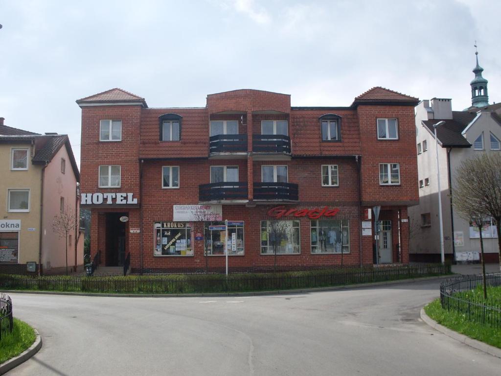 a large red brick hotel on a street at Hotel Krokus in Kamienna Góra