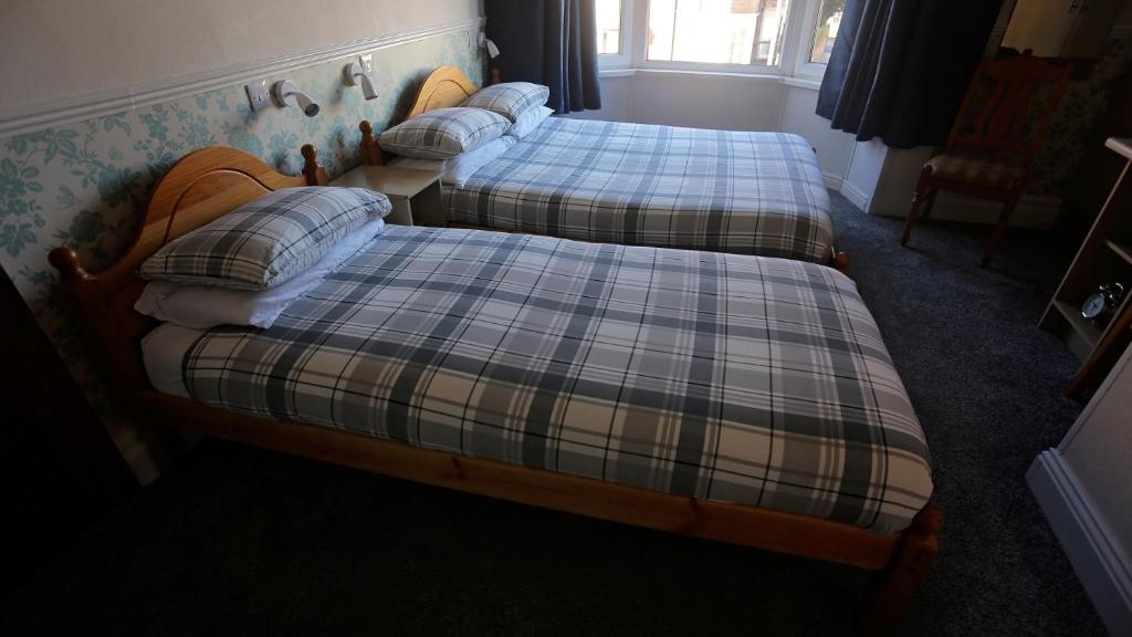 two twin beds in a room with at Annie's Guest House in South Shields