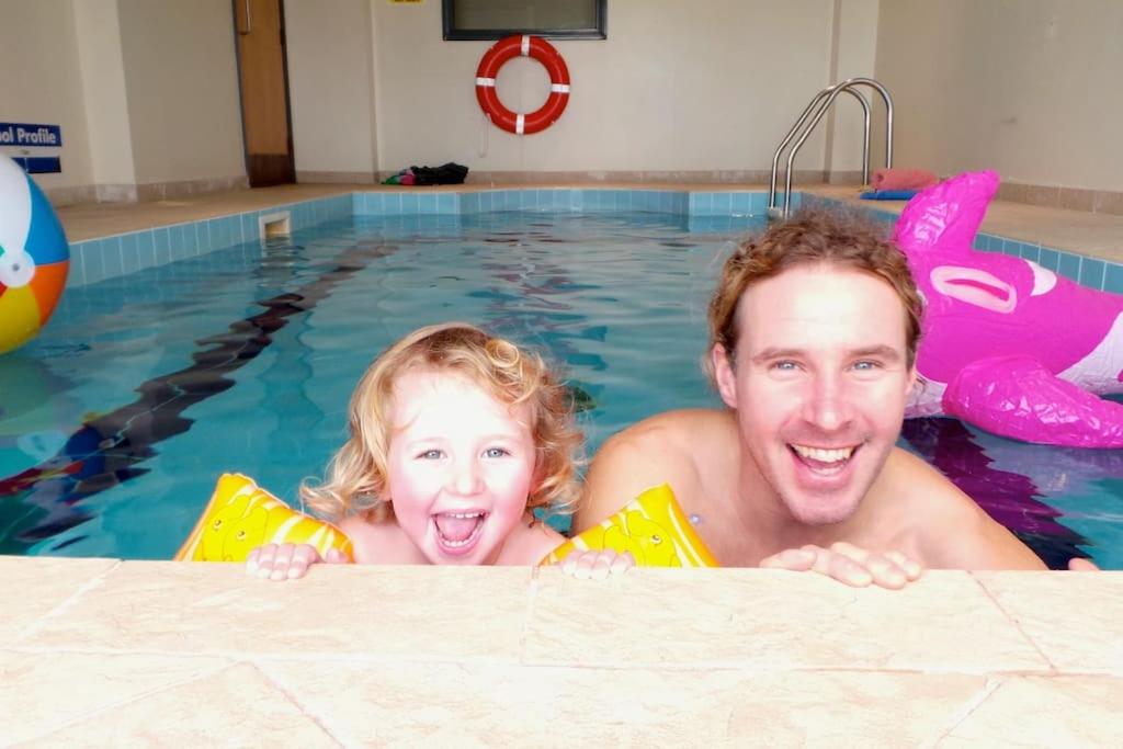 Ein Mann und ein kleines Mädchen im Schwimmbad. in der Unterkunft Horizons Apartments Newquay in Newquay