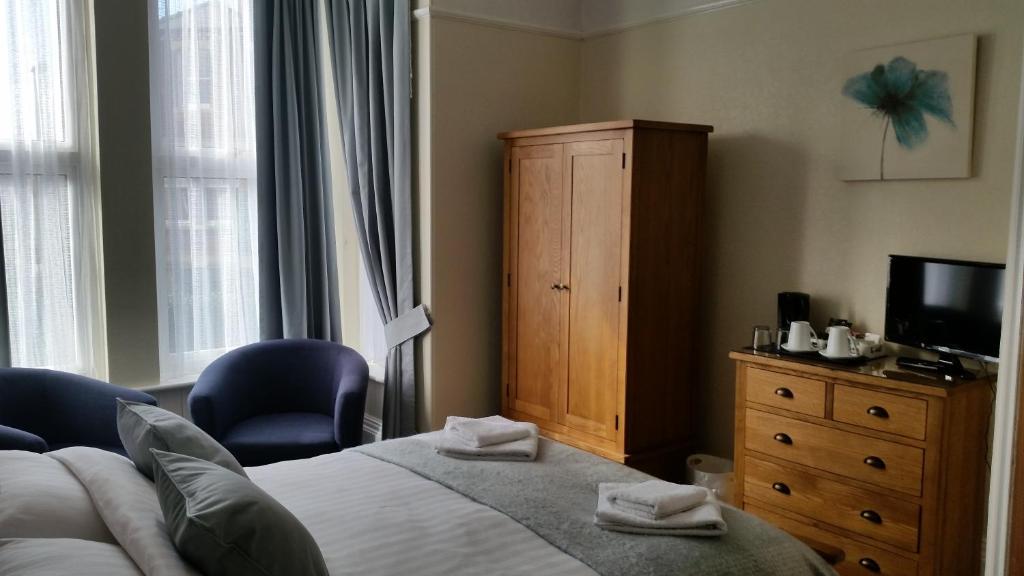 a bedroom with a bed and a dresser and a television at The Tennyson in Bridlington