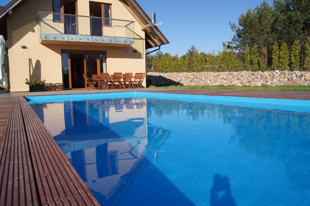 uma villa com piscina em frente a uma casa em WIGWAM Dom z basenem na Kaszubach em Sulęczyno