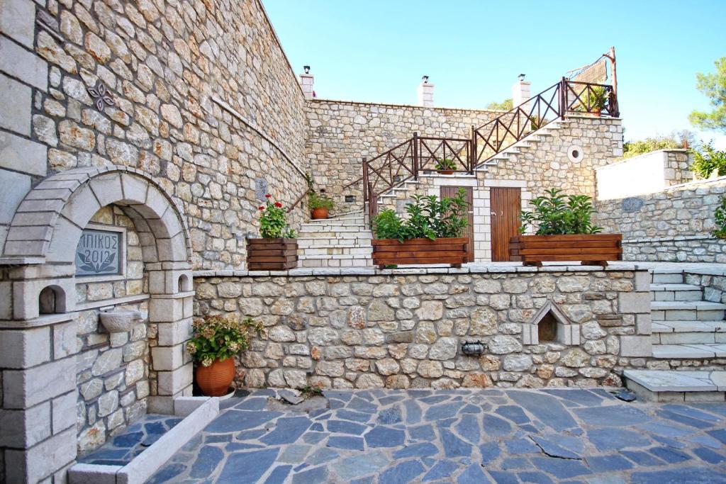 a stone building with stairs and potted plants on it at Thea Valtessinikou in Valtessiniko