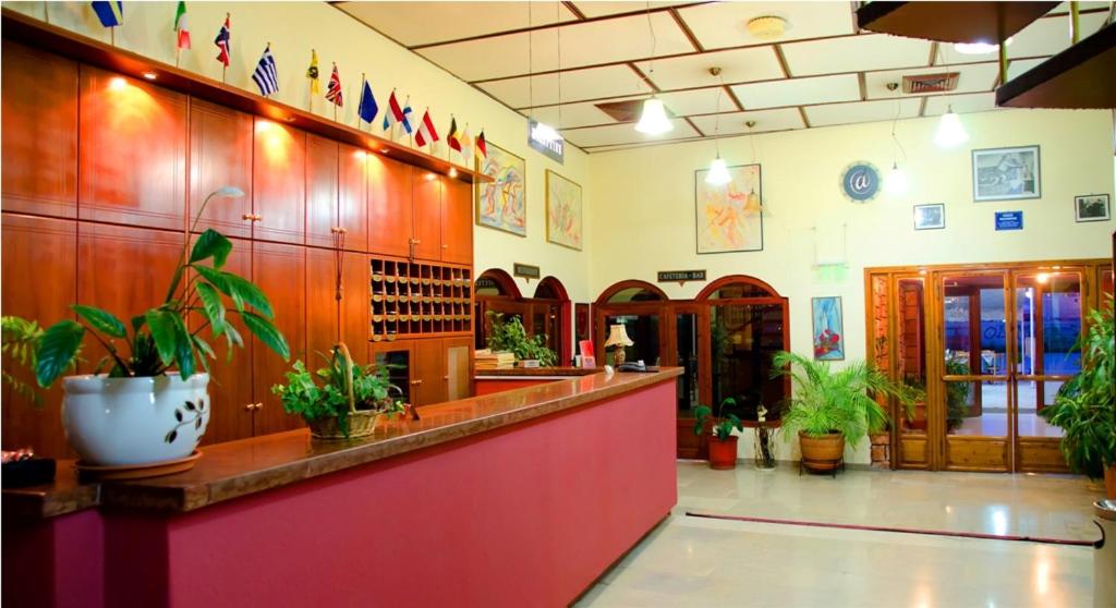 a restaurant with a counter with potted plants at Hotel Oscar in Igoumenitsa