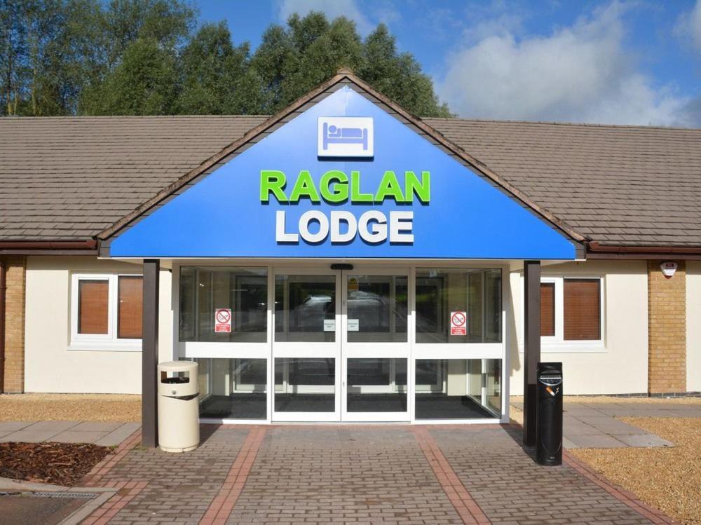 un palazzo Raleigh con un cartello sopra di Raglan Lodge a Monmouth