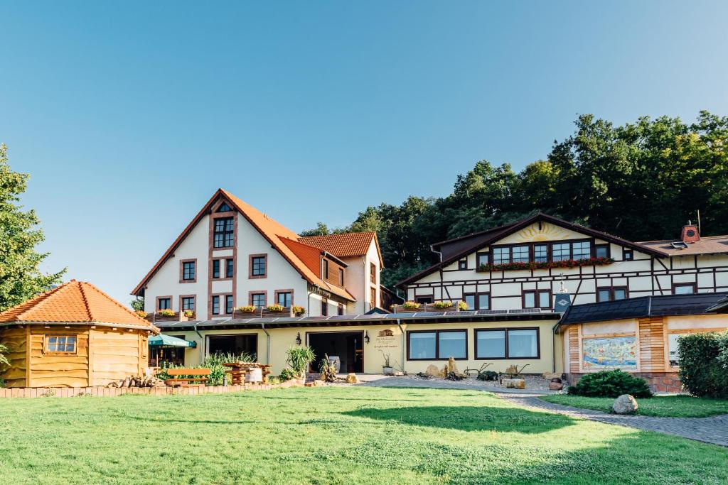 una gran casa blanca con un gran patio en Erlebnishotel "Zur Schiffsmühle" en Höfgen