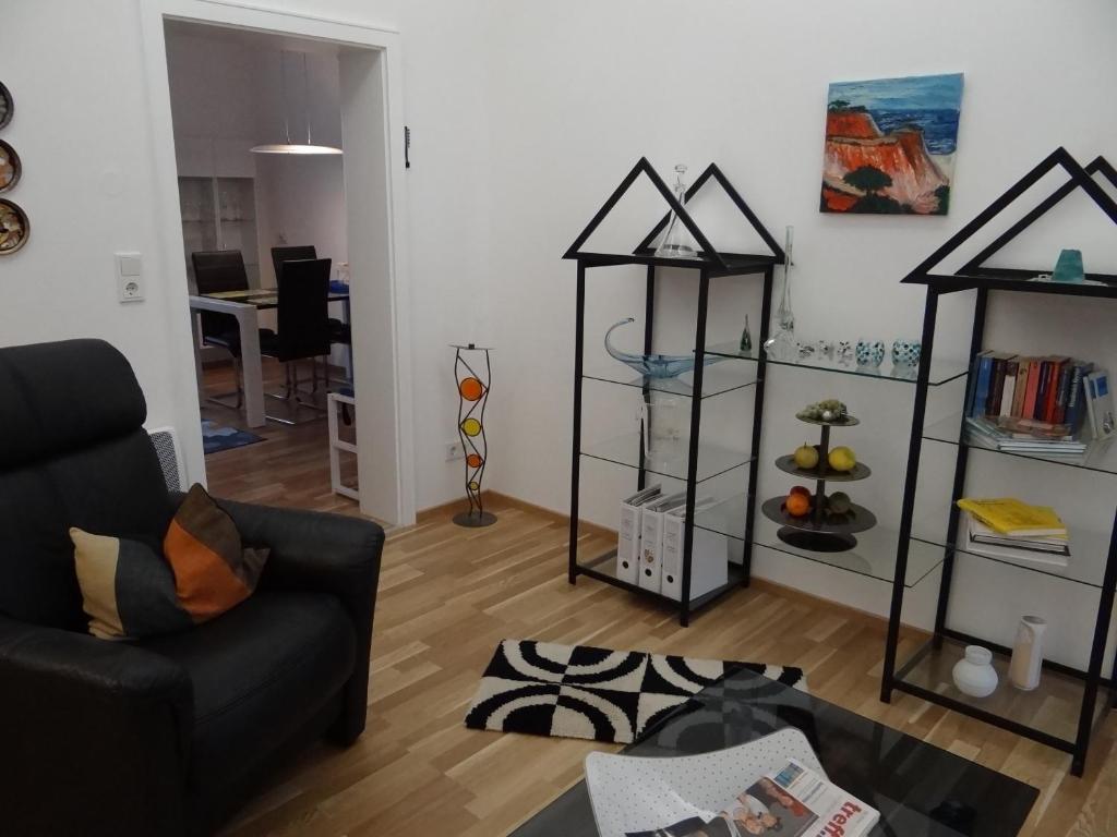 ein Wohnzimmer mit einem schwarzen Sofa und einigen Regalen in der Unterkunft Ferienwohnung Großwald in Saarbrücken