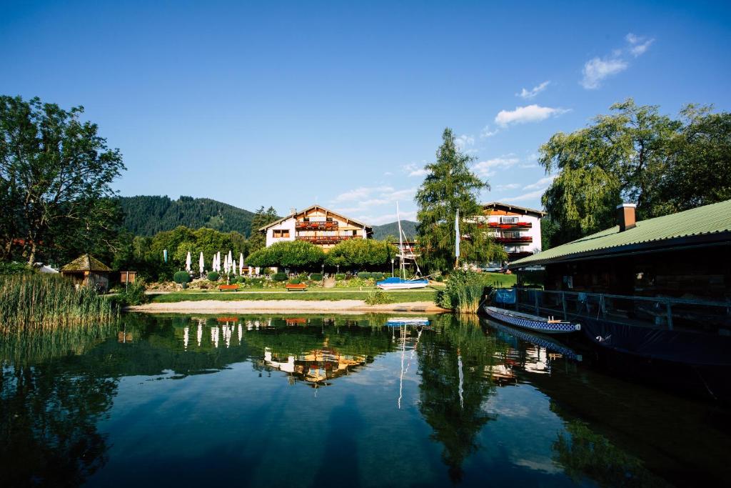 a body of water with a building next to a river at Hotel Terrassenhof in Bad Wiessee
