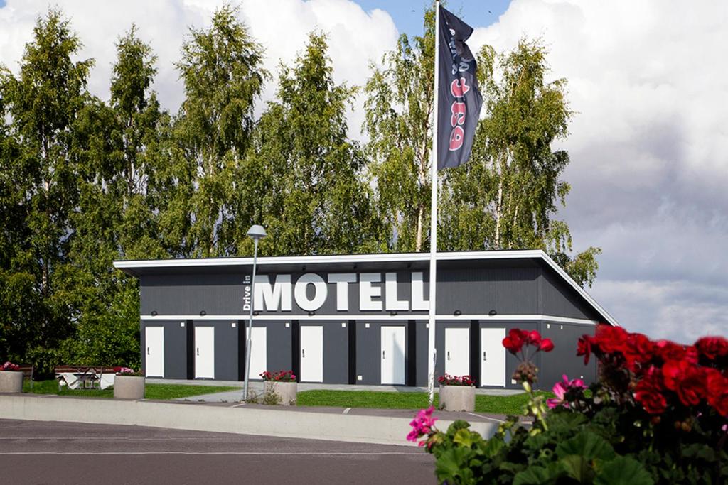 a motel with a flag in front of a building at Drive-in Motell in Mjölby