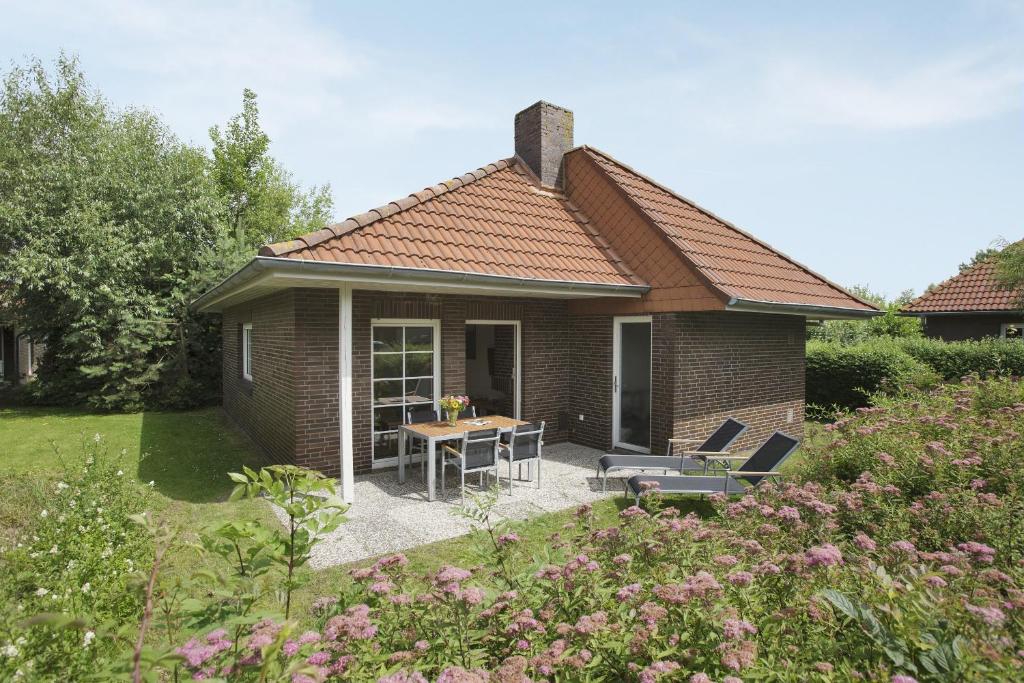 ein kleines Haus mit einem Tisch und Stühlen im Hof in der Unterkunft Center Parcs Nordseeküste Bremerhaven in Tossens