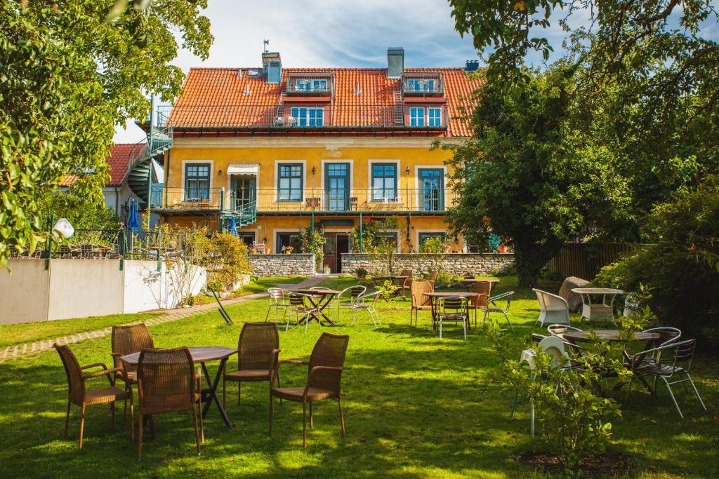 um quintal com mesas e cadeiras em frente a um edifício em Hotell Breda Blick em Visby