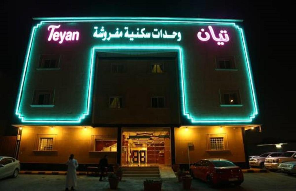 un edificio con una señal de neón delante de él en تيان, en Riad