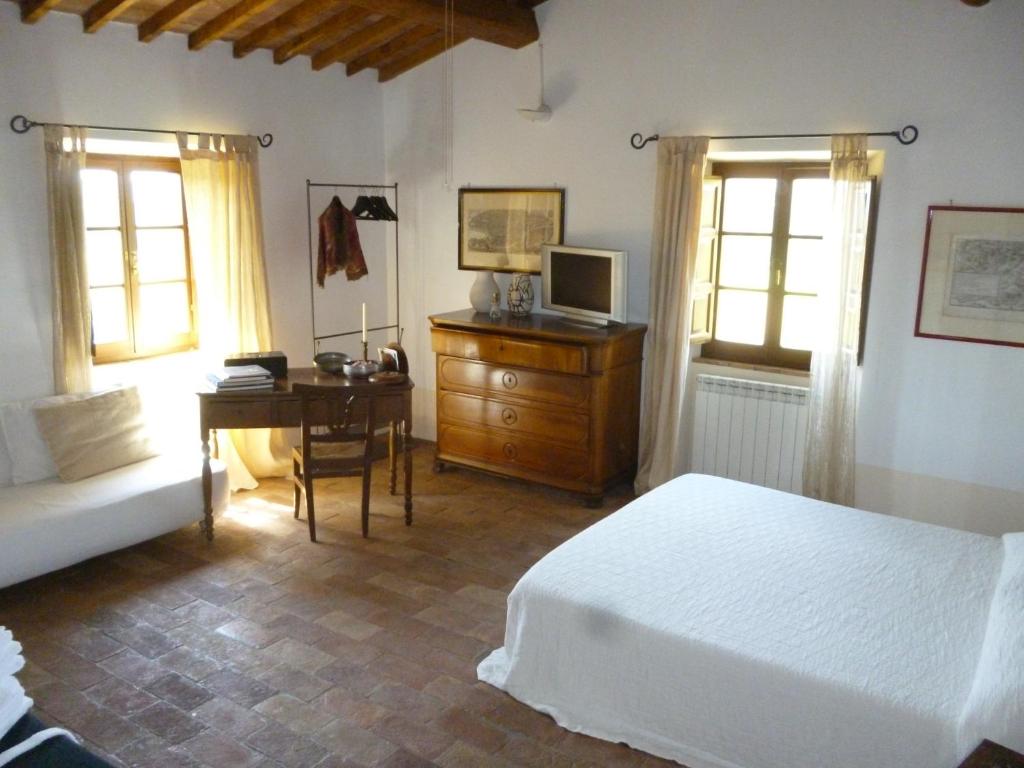 a bedroom with a bed and a desk with a computer at PoggioBa in Sovana