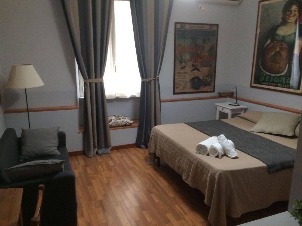 a bedroom with a bed and a chair and a window at Vacanze Romane 2 in Rome