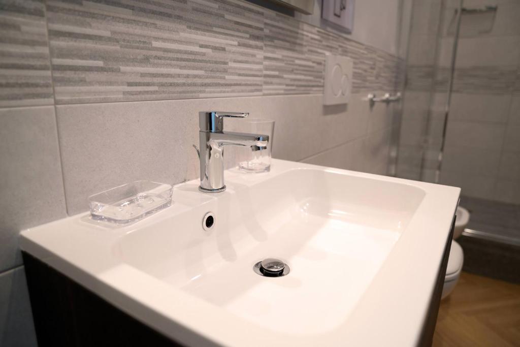 a white sink in a bathroom with a shower at Room 56 in Bari