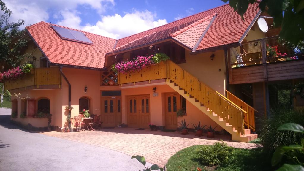 una casa con techo rojo y escalera en Apartment Beli Zajec, en Mozirje