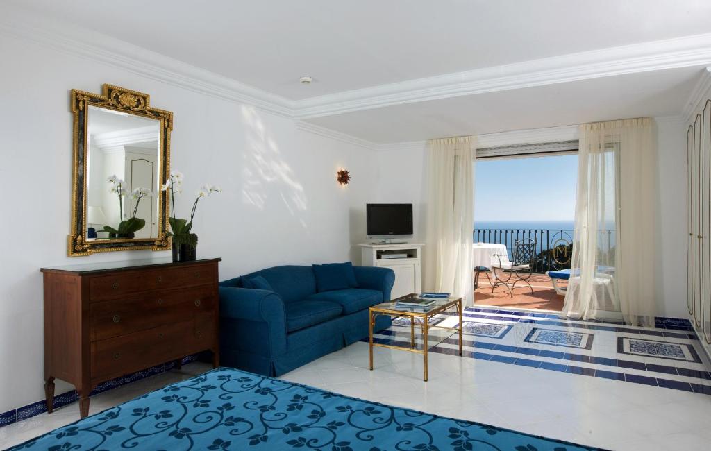 a living room with a blue couch and a mirror at Casa Morgano in Capri
