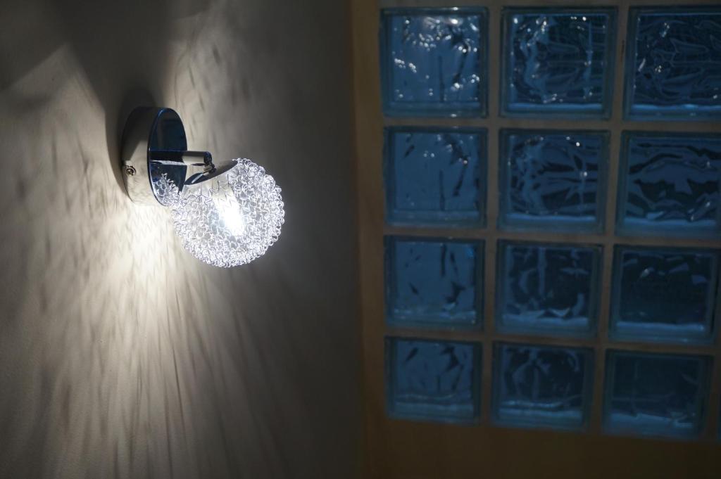 una lámpara fija en una pared con una ventana en Duplex Ribadeo, en Ribadeo