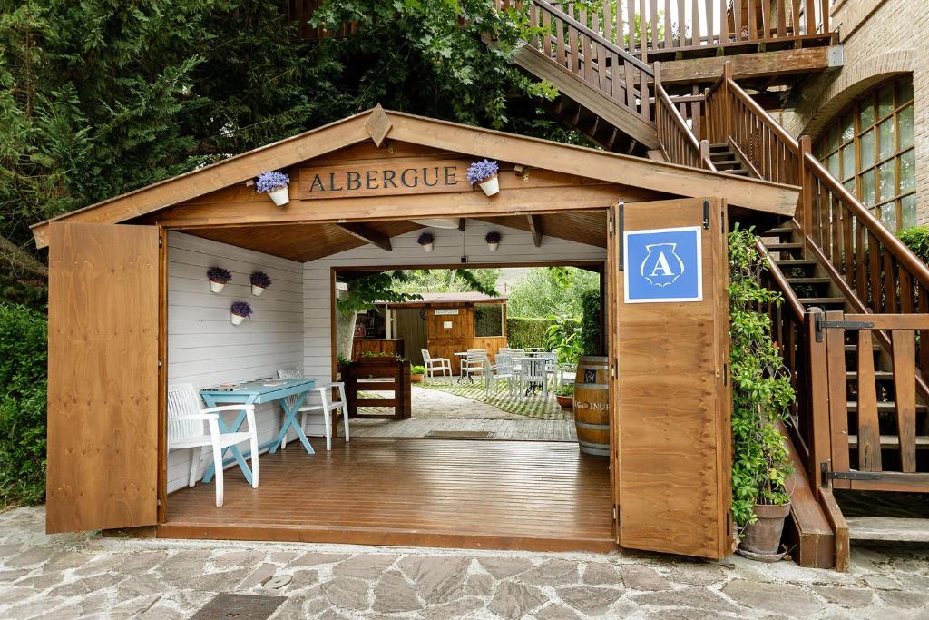 eine Holzgarage mit einer Treppe und einem Tisch in der Unterkunft Albergue Jakue in Puente la Reina