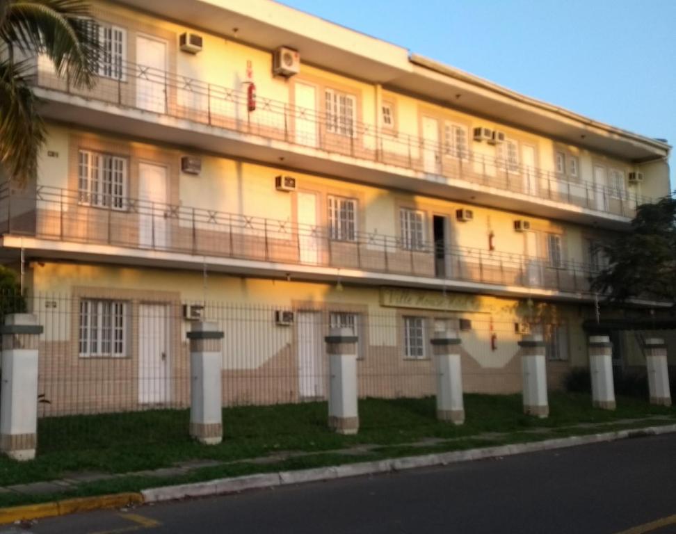 a building with balconies on the side of a street at Ville House Hotel Canoas in Canoas