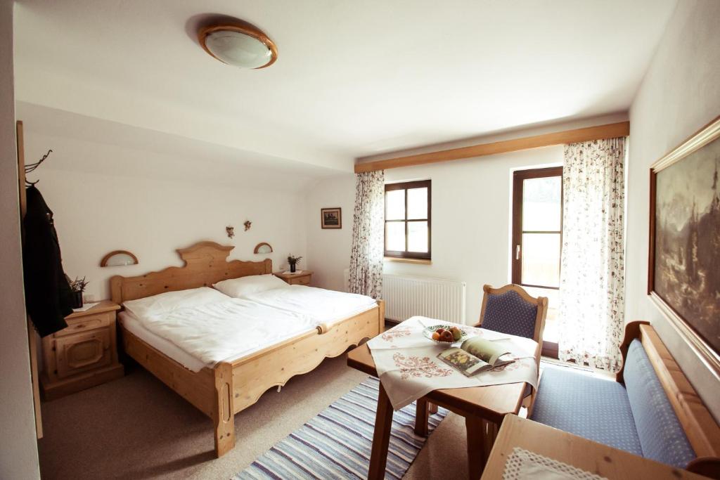 Un dormitorio con una cama y una mesa. en Frühstückspension Windlegern, en Neukirchen