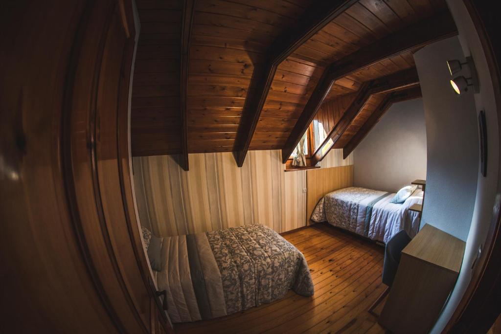 a small bedroom with a bed in a wooden ceiling at La Borda de Garbi in Piedrafita de Jaca
