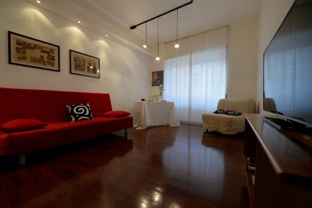 ローマにあるAbbracciaroma Casa Vacanzeのリビングルーム(赤いソファ、テレビ付)