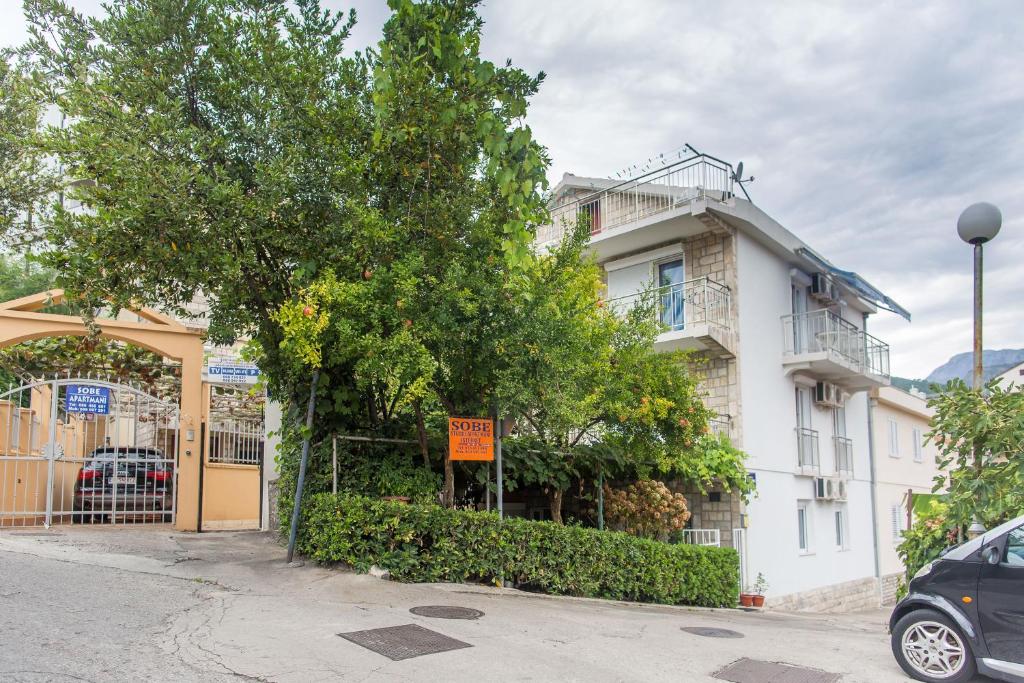 un edificio blanco con un árbol delante en Guest House Vucicevic en Budva