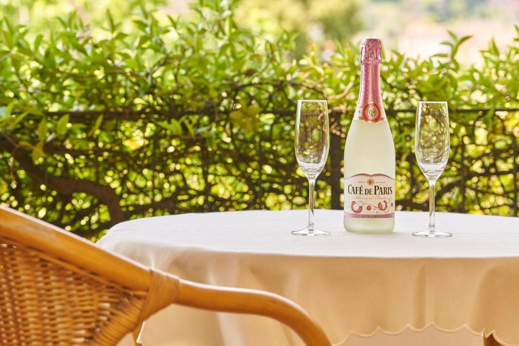 Una botella de champán sentada en una mesa con dos copas. en Ferienwohnung Isabella en Ascona