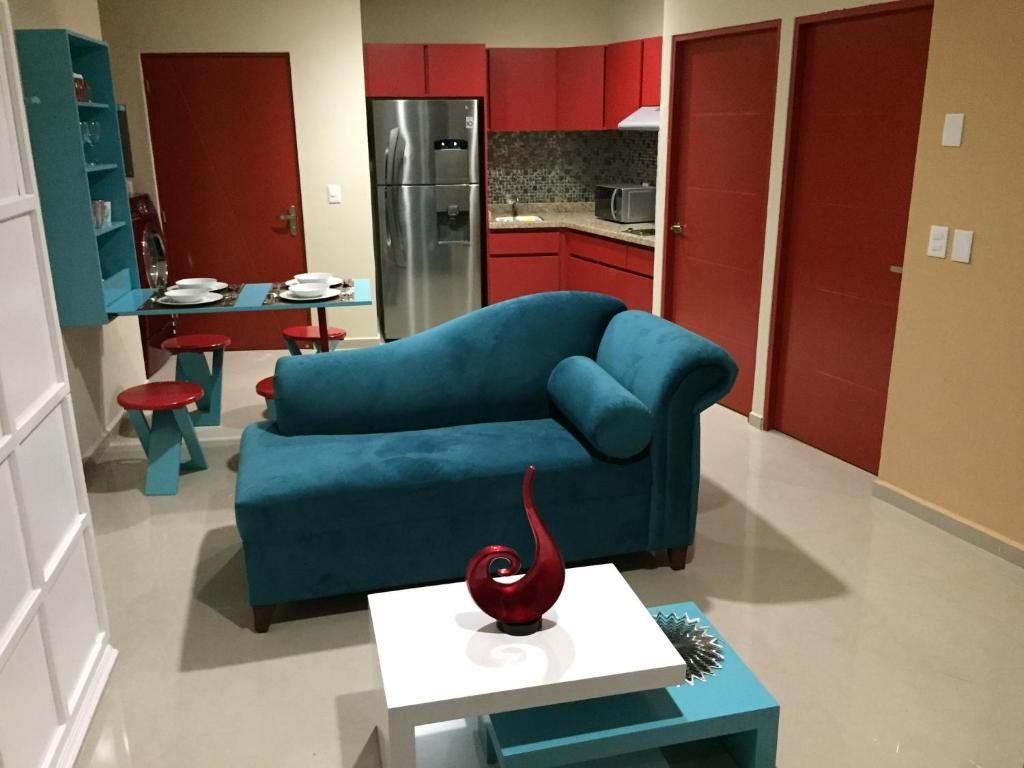 sala de estar con sofá azul y cocina en Playa y alberca en Zona Marina, en Mazatlán