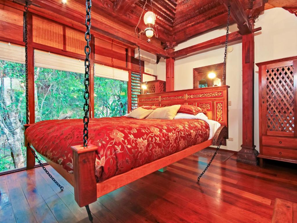 a bedroom with a swing bed in a room at Wollumbin Palms Rainforest Retreat in Uki
