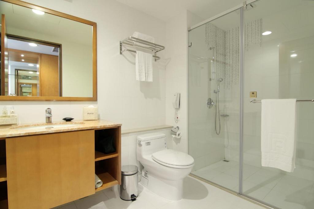 a bathroom with a toilet and a glass shower at Fushin Hotel Taichung in Taichung