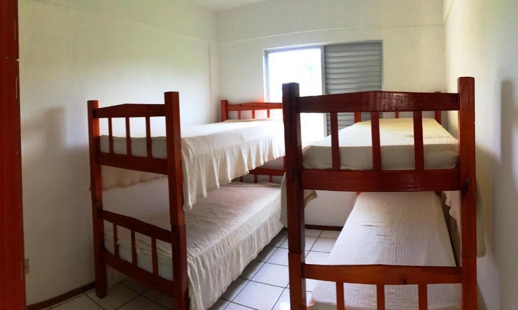 two bunk beds in a room with a window at Residencial Baia Blanca in Florianópolis