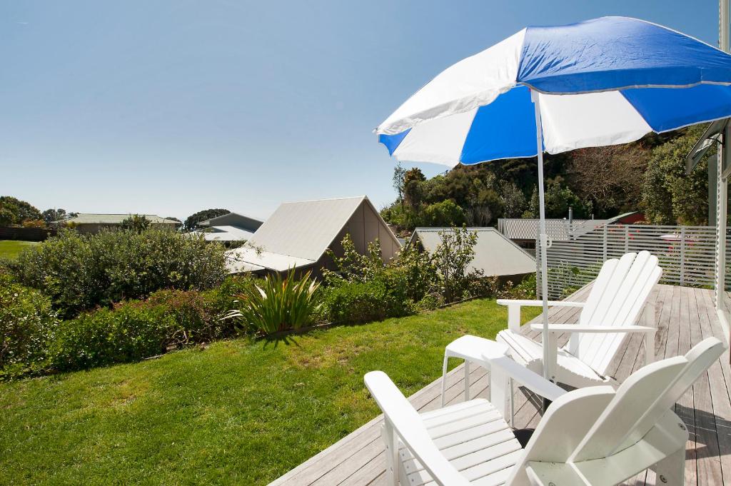 a pair of chairs and an umbrella on a deck at Robins Nest in Russell