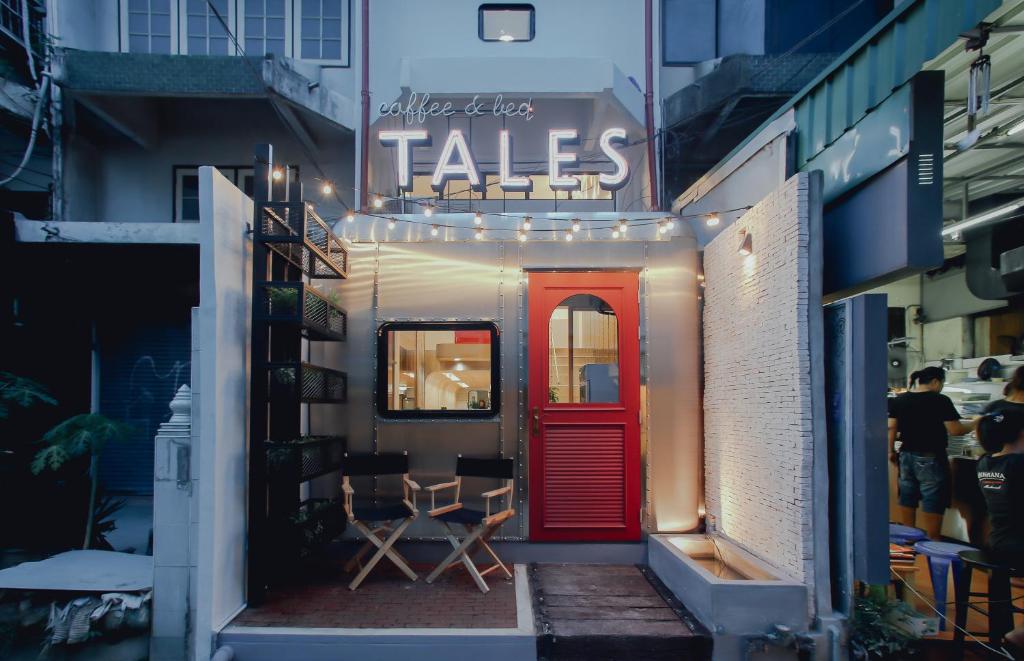 a building with a red door and a table and chairs at Tales Khaosan (Cafe & Hostel) in Bangkok