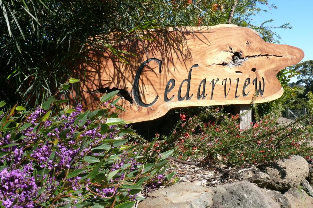 een bord voor een tuin met paarse bloemen bij Cedarview Bed & Breakfast in Beechmont