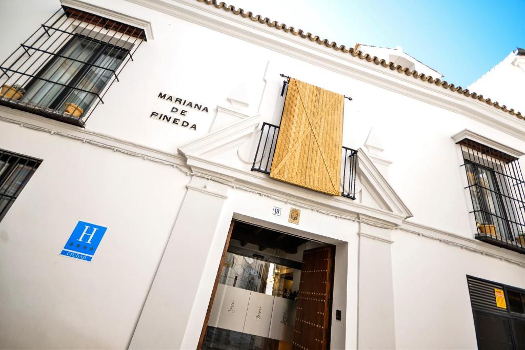 a facade of a white building with a window at Hotel Legado Alcazar in Seville