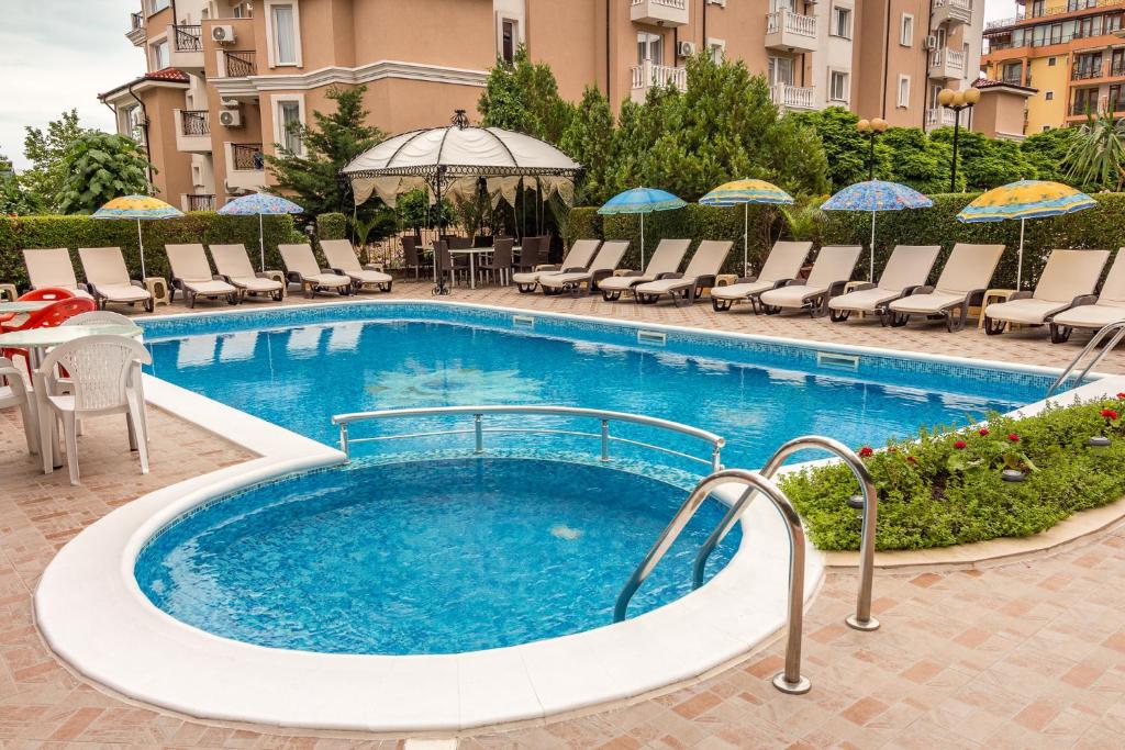 a large swimming pool with chairs and umbrellas at Family Hotel Venera in Sveti Vlas